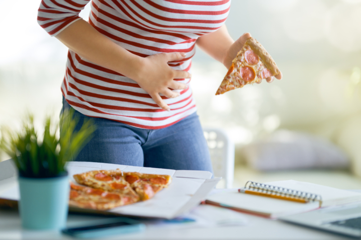 Woman,Eating,Pizza,On,The,Desk,At,Work,And,Having